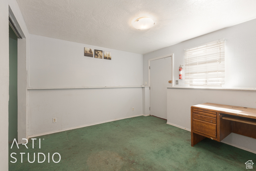 Interior space featuring a textured ceiling and dark colored carpet