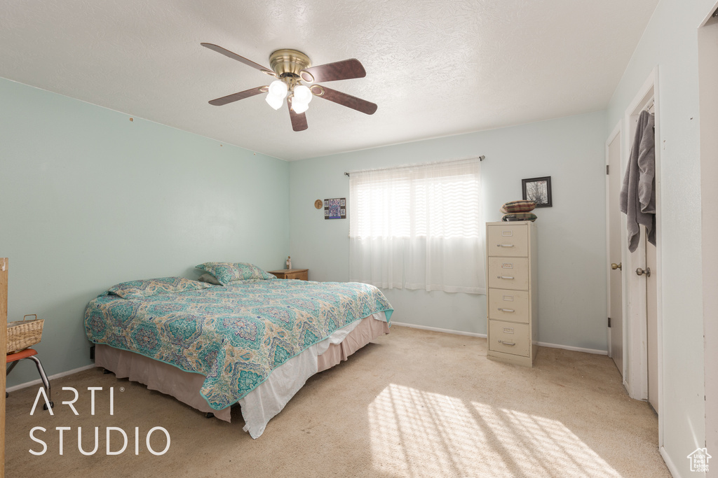 Carpeted bedroom featuring ceiling fan