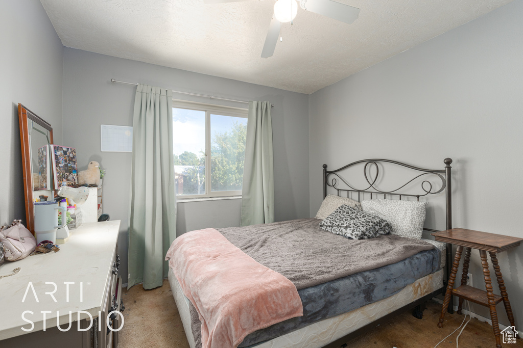 Bedroom featuring ceiling fan, carpet floors, and a textured ceiling