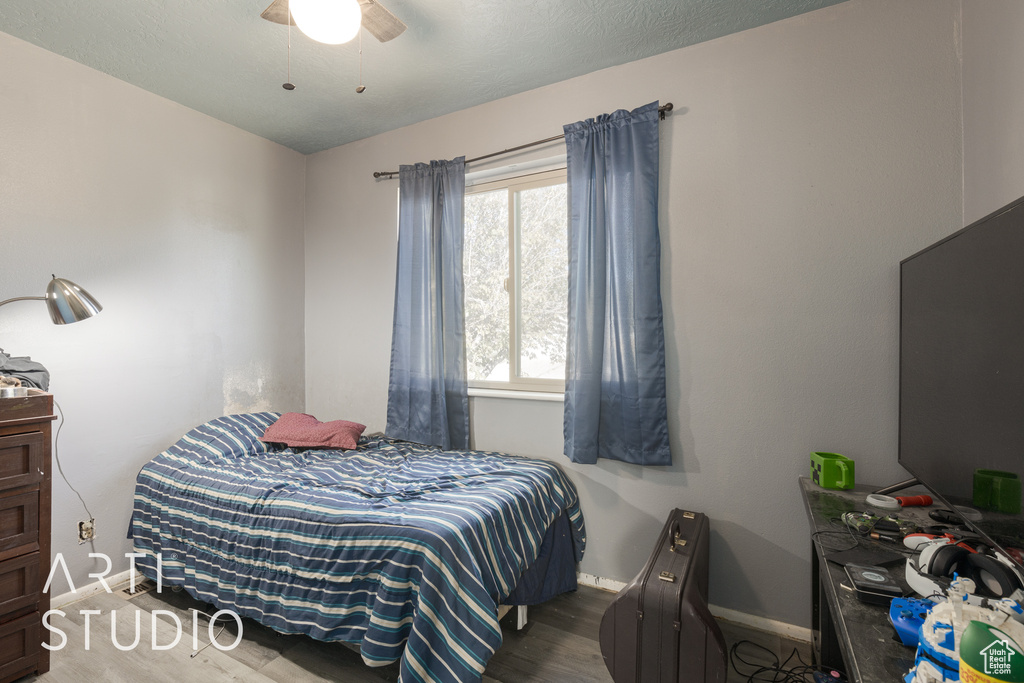 Bedroom with ceiling fan and hardwood / wood-style floors