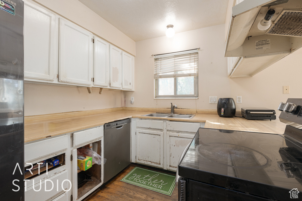 Kitchen with black electric range, sink, range hood, and white cabinets