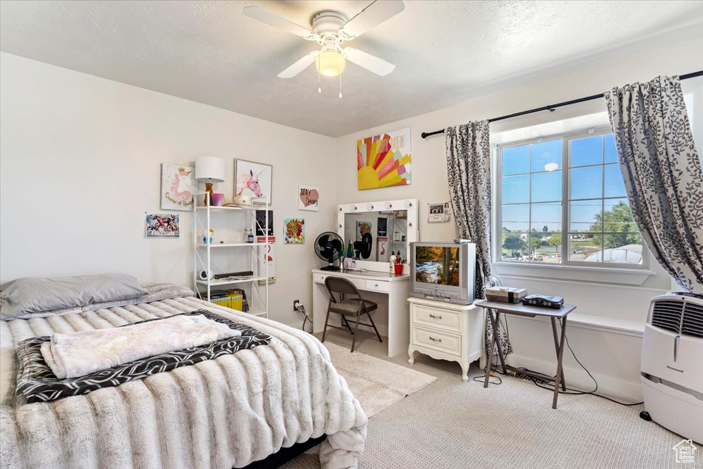 Bedroom featuring a textured ceiling, ceiling fan, and light colored carpet