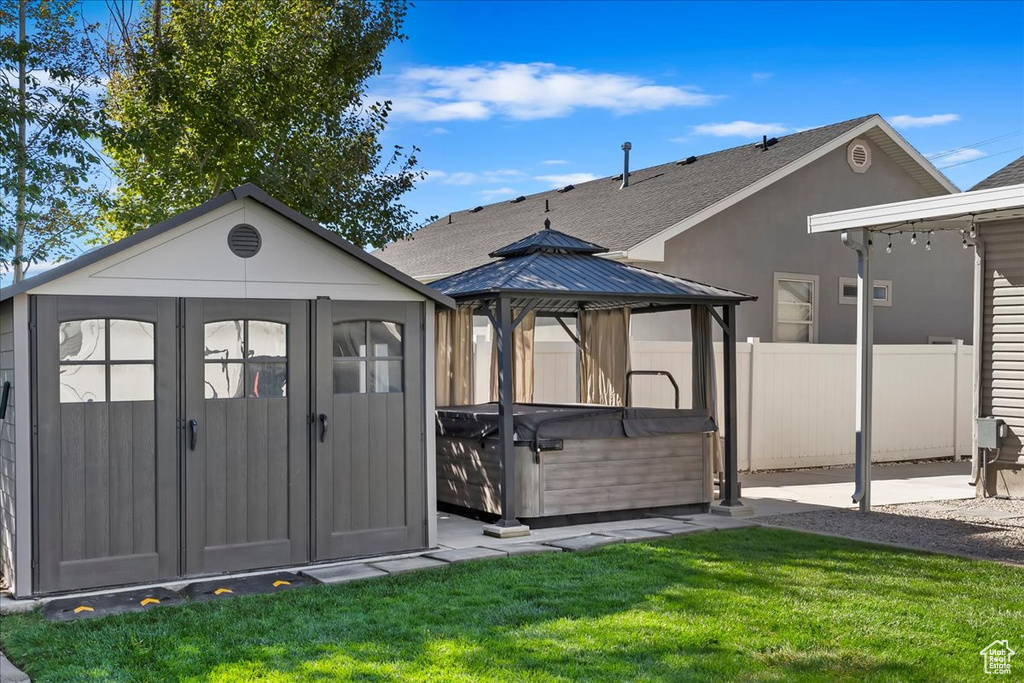 View of outbuilding featuring a gazebo, a yard, and a hot tub