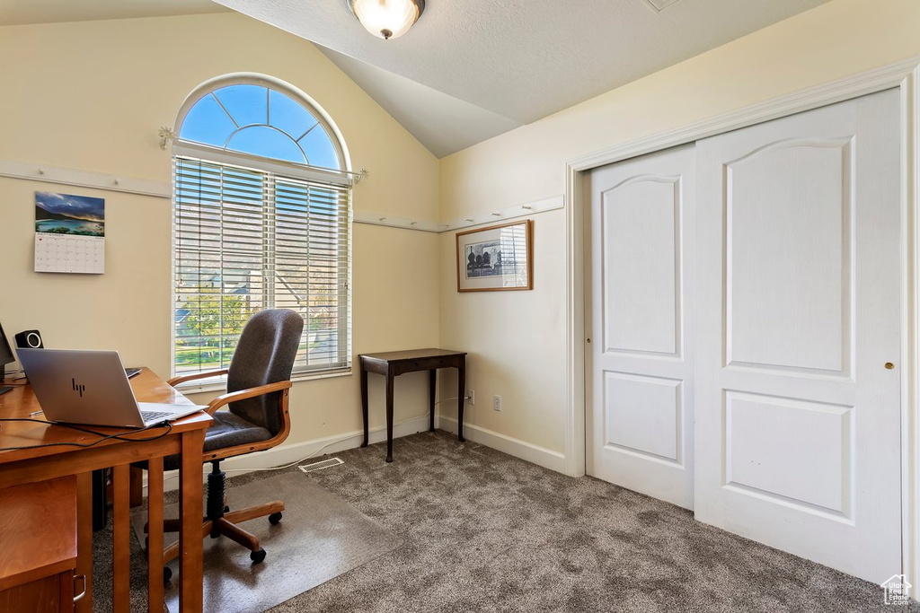 Carpeted office space featuring vaulted ceiling