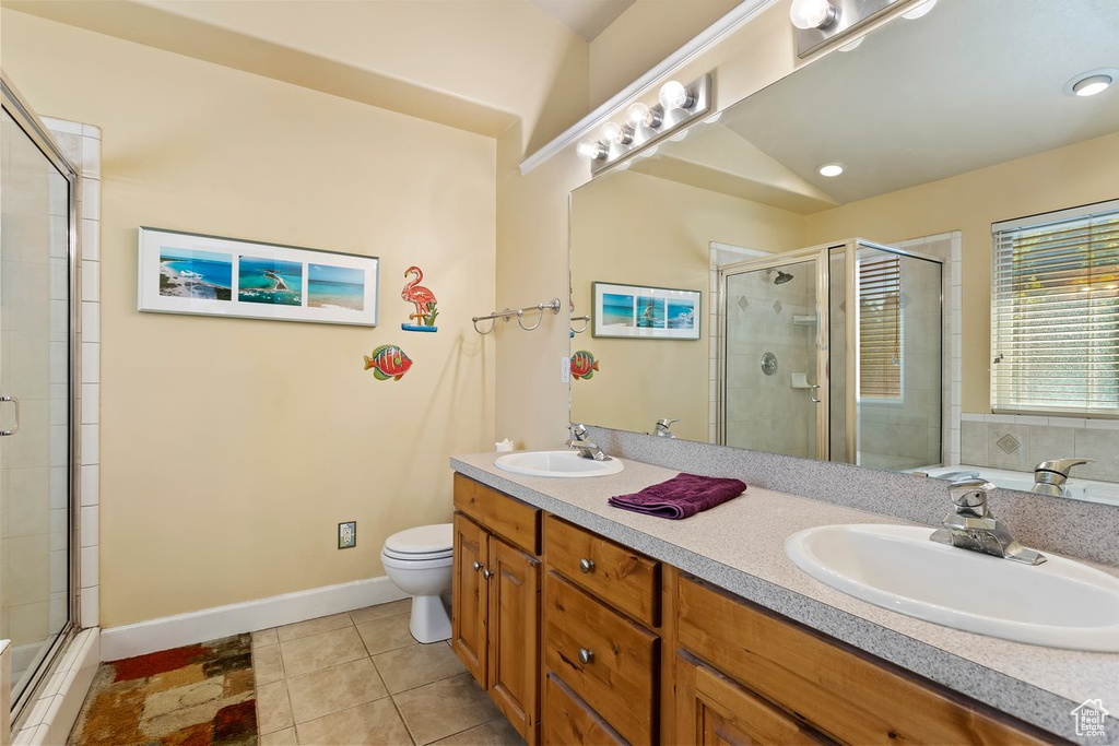 Bathroom featuring walk in shower, tile patterned flooring, vanity, and toilet