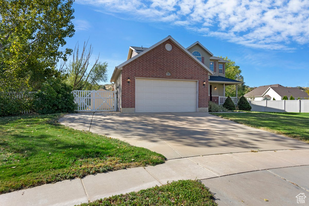 View of property featuring a front yard and a garage