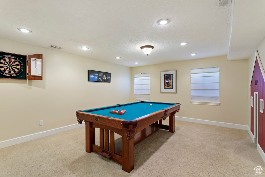 Recreation room with light carpet, pool table, and a textured ceiling