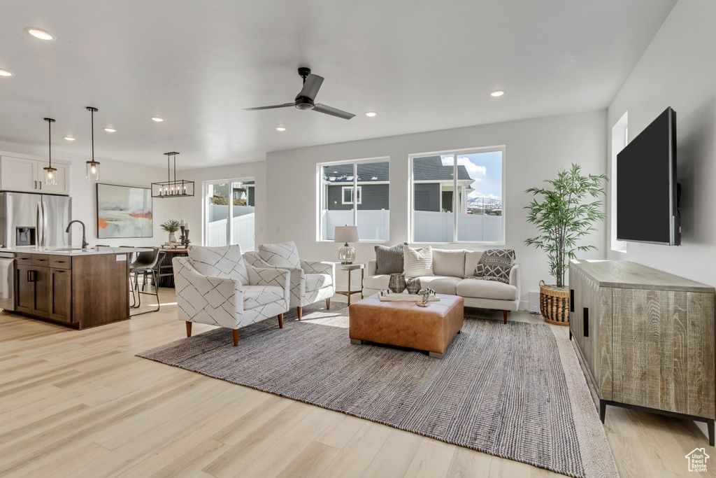 Living room featuring light hardwood / wood-style flooring, ceiling fan, and sink