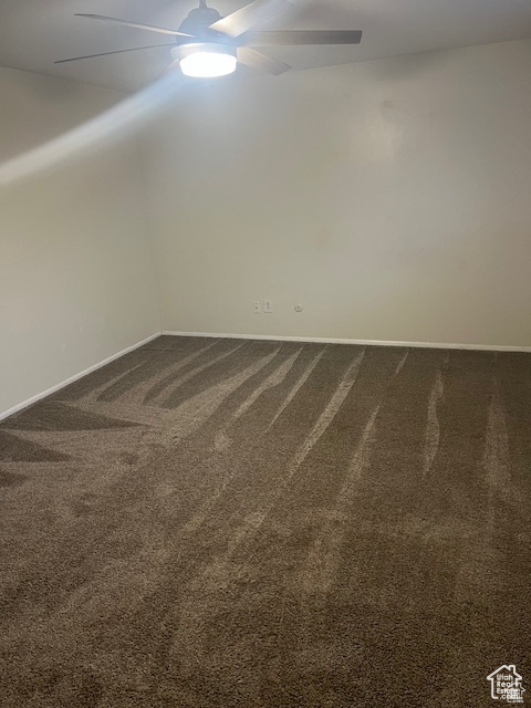 Empty room with carpet floors and ceiling fan