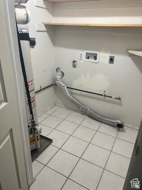 Laundry area with hookup for an electric dryer, hookup for a washing machine, and light tile patterned flooring