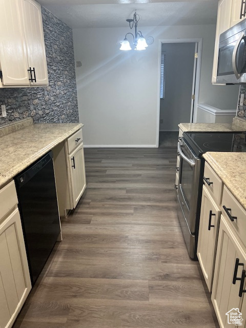 Kitchen featuring a notable chandelier, stainless steel appliances, hanging light fixtures, and dark hardwood / wood-style flooring