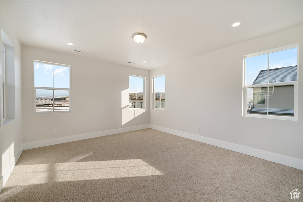 Carpeted empty room featuring plenty of natural light