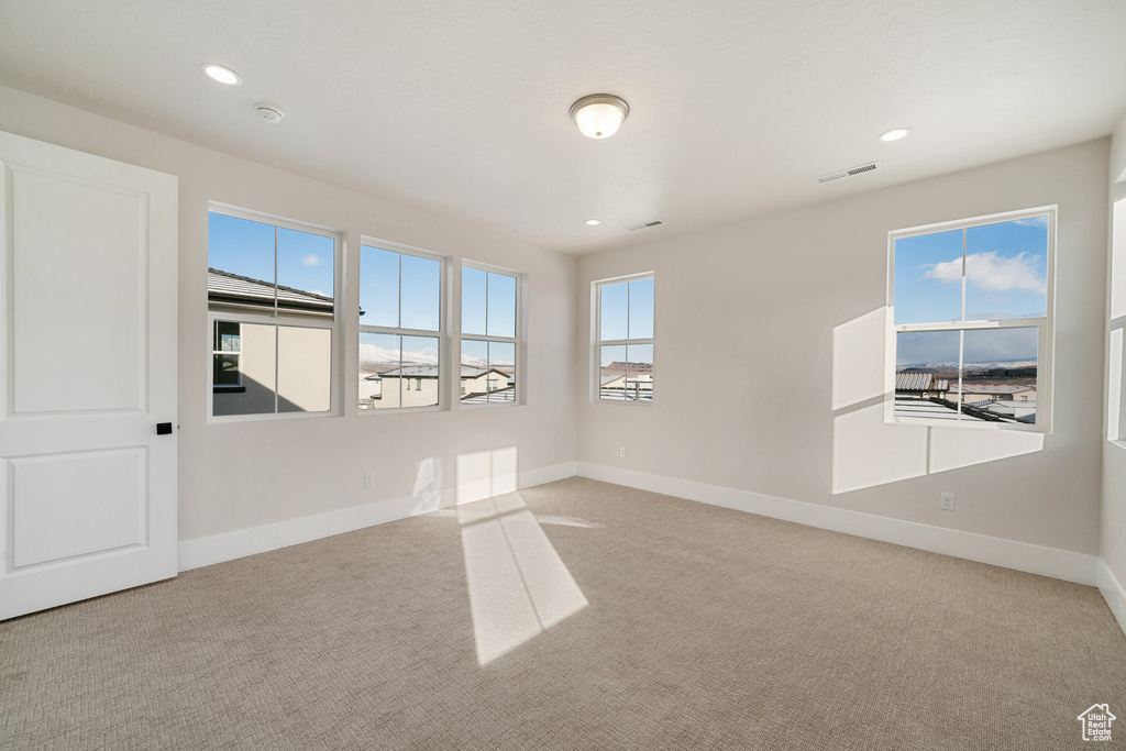 Empty room featuring light colored carpet