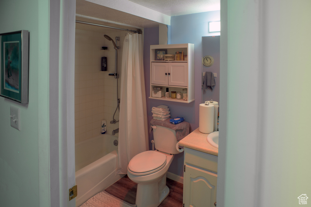 Full bathroom with shower / bath combo, vanity, toilet, and hardwood / wood-style flooring