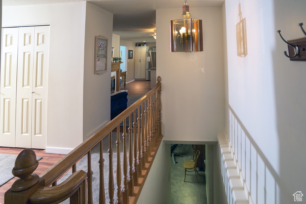 Hallway featuring hardwood / wood-style floors and a notable chandelier