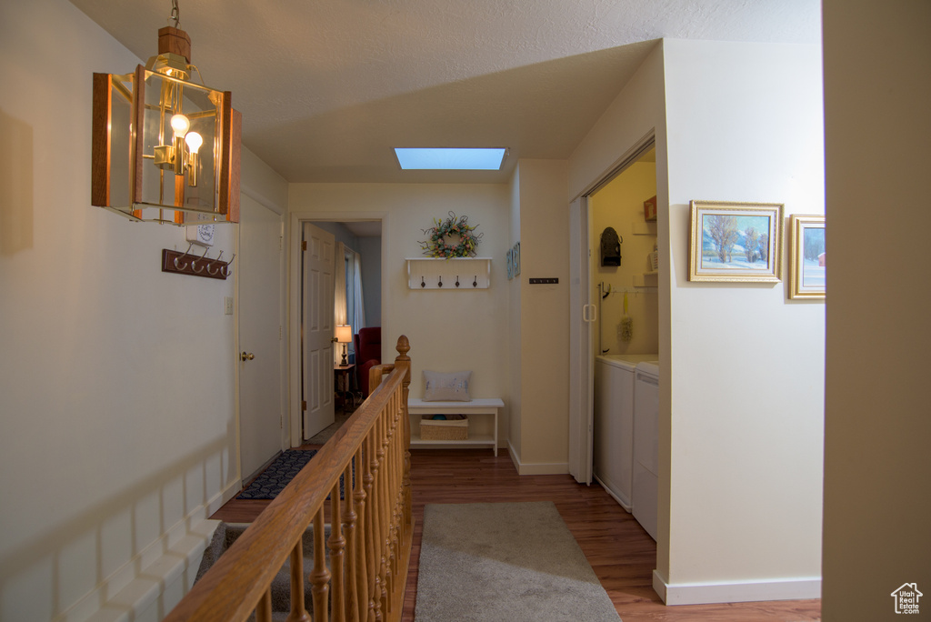 Hall with light wood-type flooring, a skylight, and washer and clothes dryer