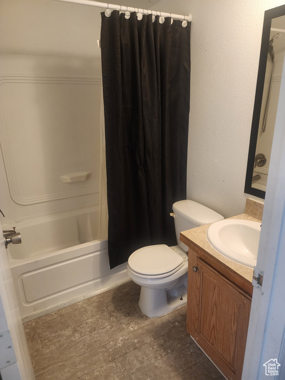 Bathroom featuring shower / tub combo with curtain, toilet, and vanity