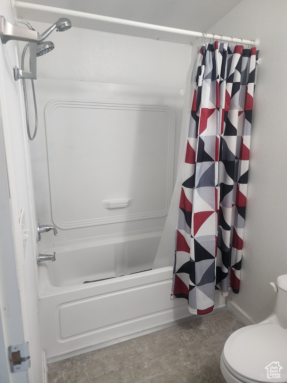 Full bath featuring shower / bath combo with shower curtain and toilet