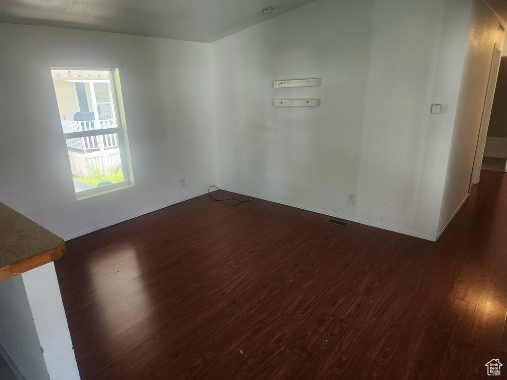 Empty room with dark wood finished floors and baseboards