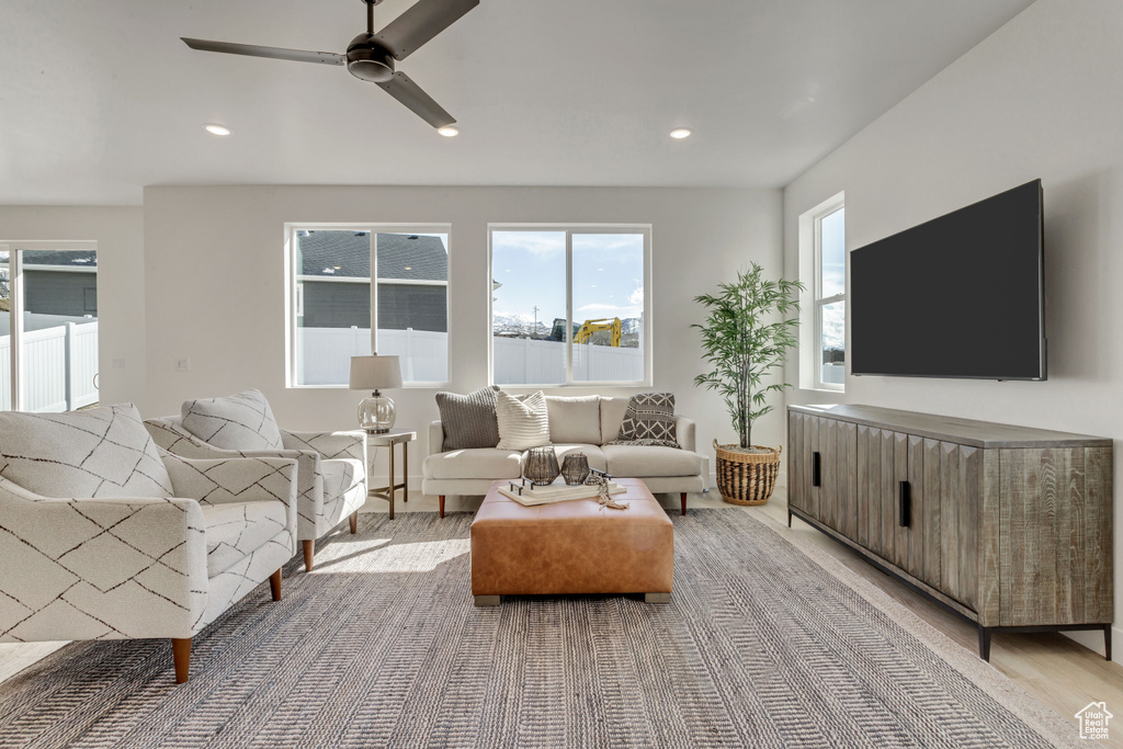 Living room with ceiling fan and light hardwood / wood-style floors