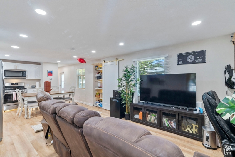 Living room with light hardwood / wood-style flooring and a barn door