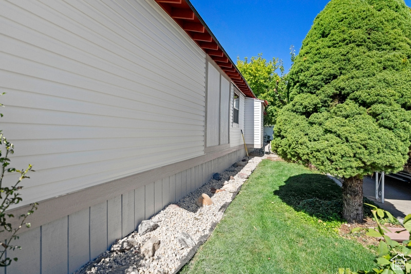 View of property exterior featuring a lawn