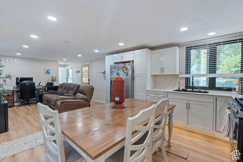 Dining area with light wood-type flooring and sink