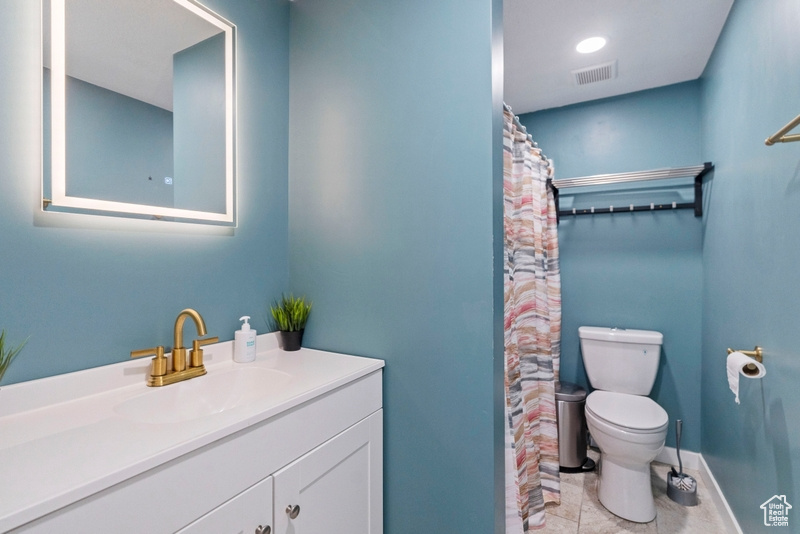 Bathroom with vanity, toilet, and tile patterned floors