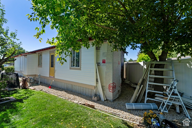 View of side of home featuring a yard