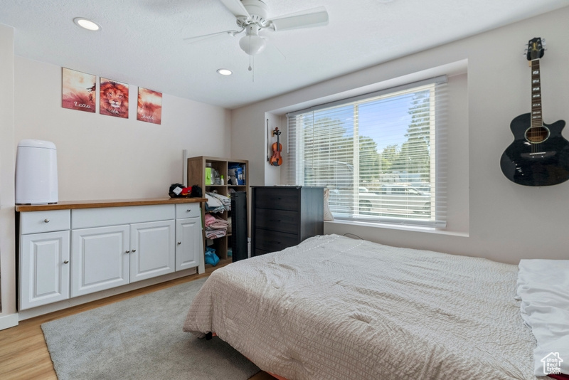 Bedroom with light hardwood / wood-style floors and ceiling fan