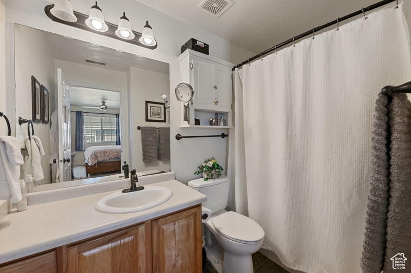 Bathroom featuring tile patterned floors, vanity, and toilet