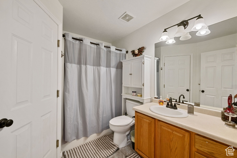 Bathroom featuring vanity, tile patterned flooring, toilet, and a shower with shower curtain