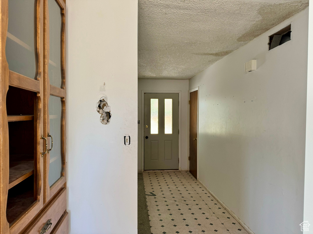 Corridor featuring a textured ceiling