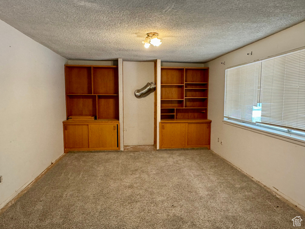 Unfurnished bedroom featuring light colored carpet and a textured ceiling