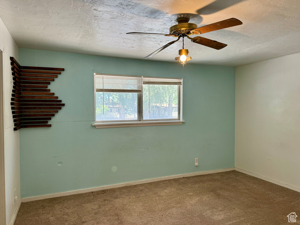 Unfurnished room with carpet, ceiling fan, and a textured ceiling