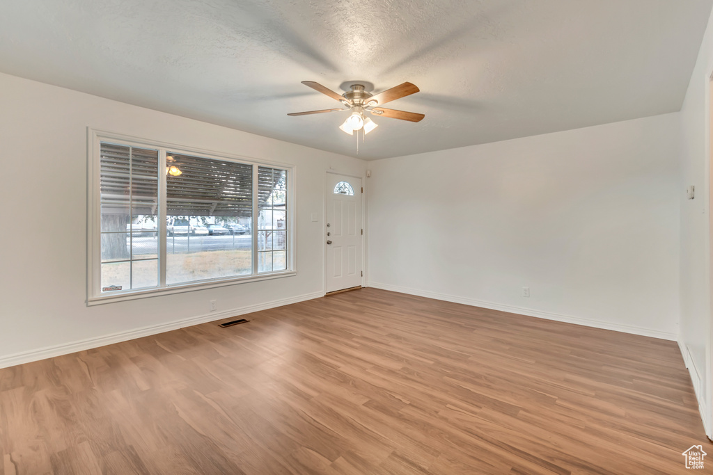 Entrance foyer with a textured ceiling, light hardwood / wood-style floors, and ceiling fan