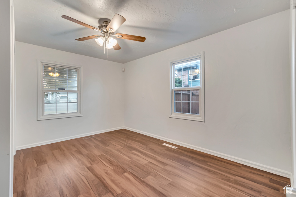 Unfurnished room with light wood-type flooring, a textured ceiling, and ceiling fan