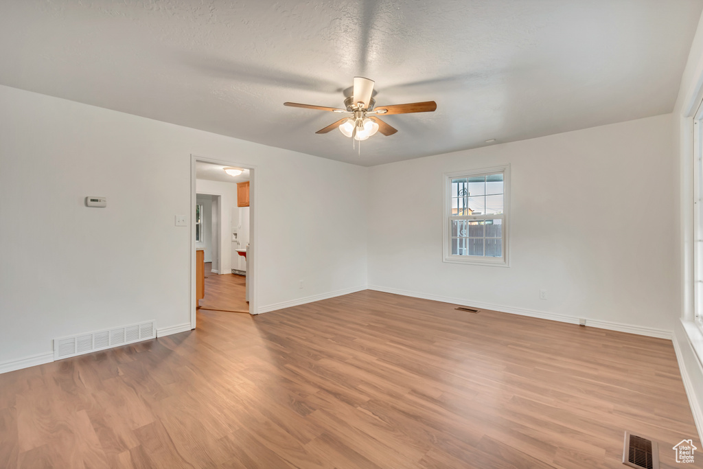 Unfurnished room featuring ceiling fan, a textured ceiling, and light hardwood / wood-style flooring