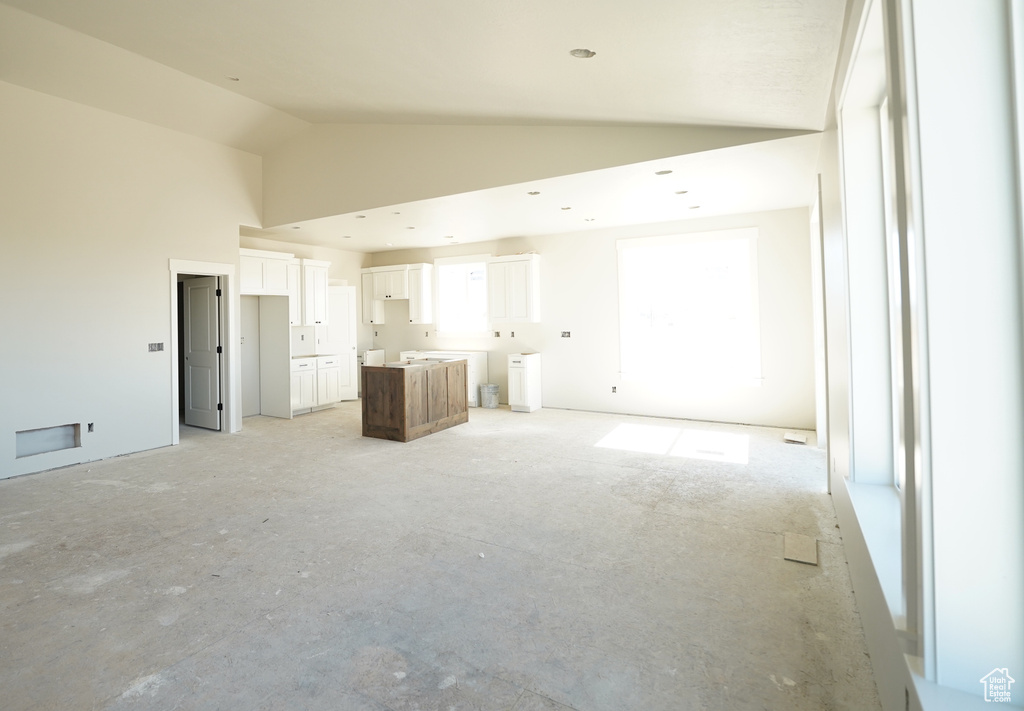 Unfurnished living room featuring high vaulted ceiling