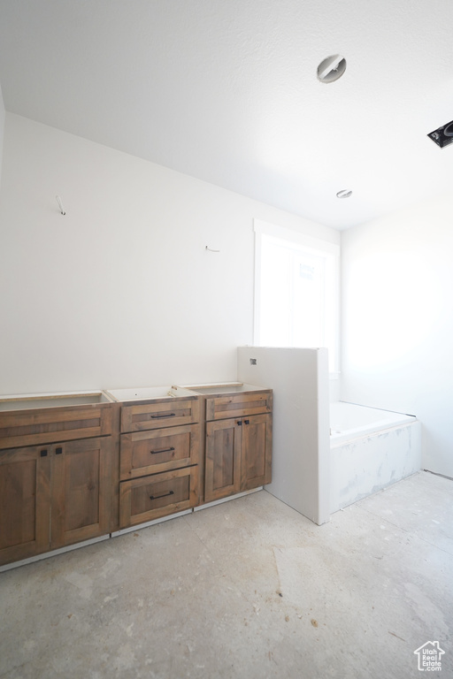 Interior space with concrete flooring and a bathing tub