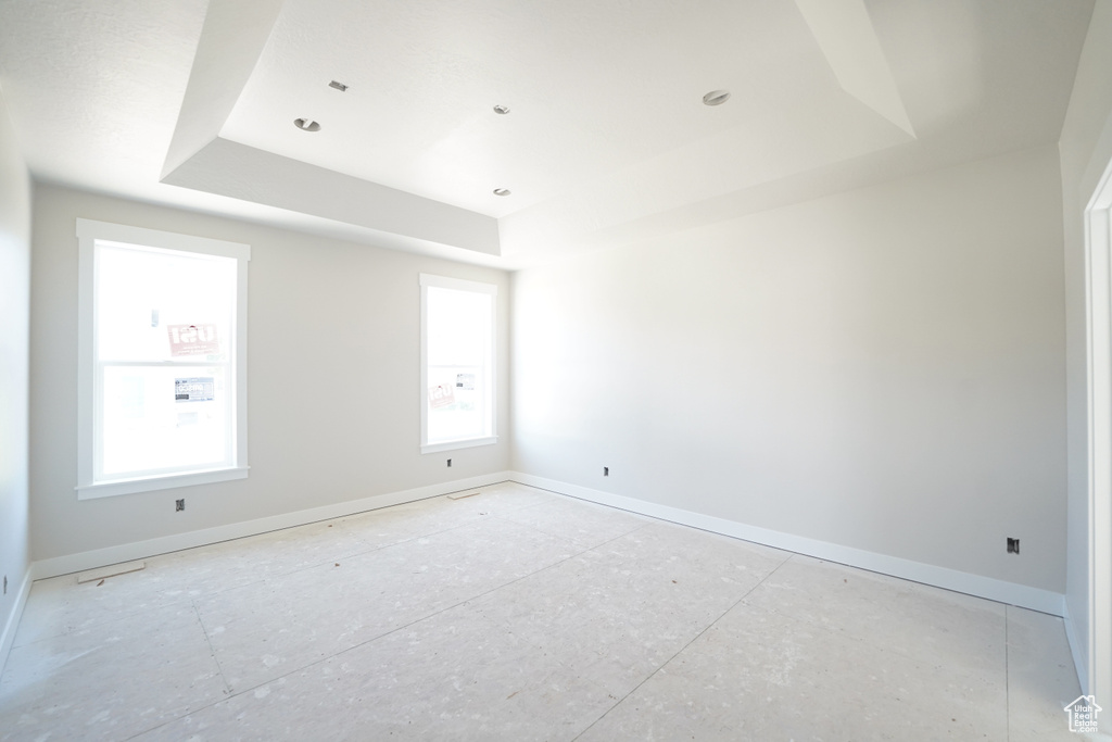 Unfurnished room with a tray ceiling