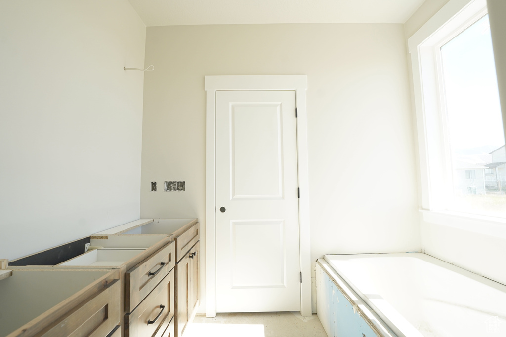 Bathroom featuring a tub to relax in, vanity, and a wealth of natural light