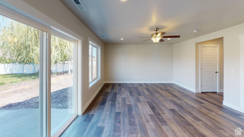 Spare room featuring ceiling fan and dark wood-type flooring