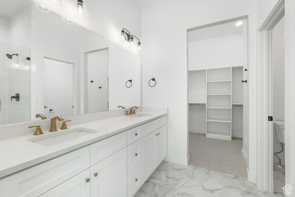 Bathroom featuring vanity, toilet, and an enclosed shower