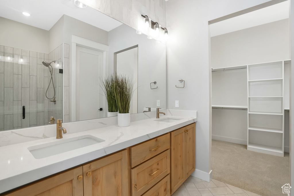 Bathroom with tile patterned floors, walk in shower, and vanity