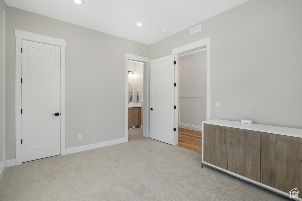 Interior space featuring light carpet and ensuite bathroom