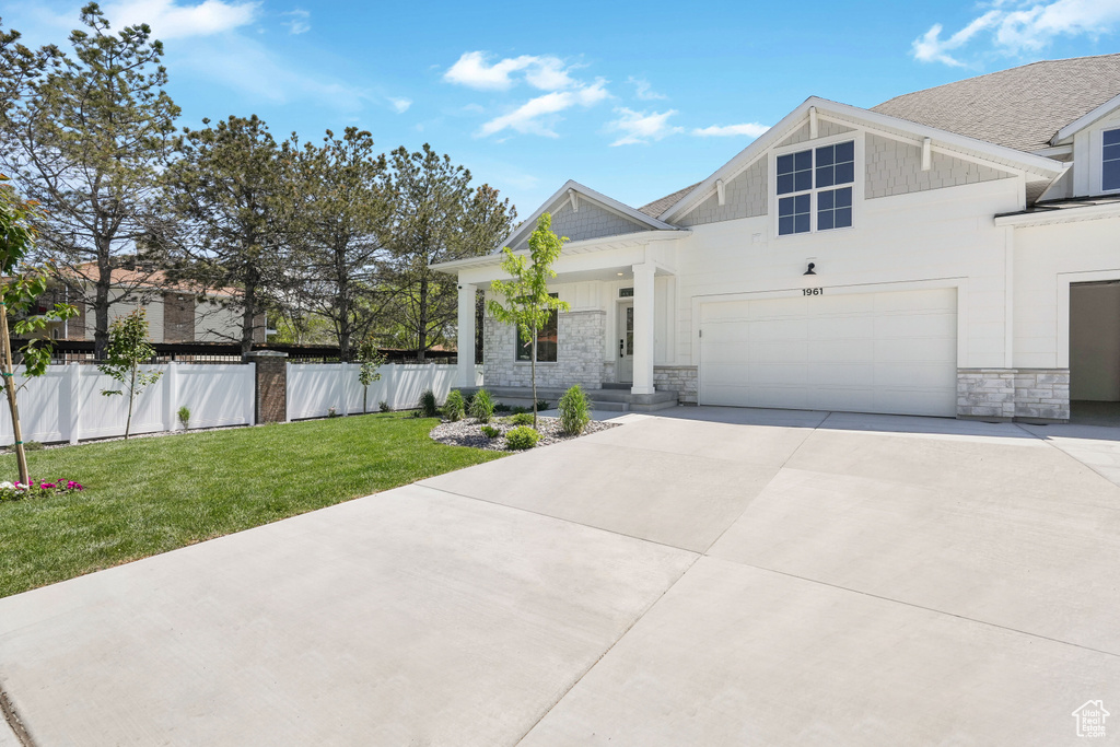 View of front of property featuring a front yard and a garage