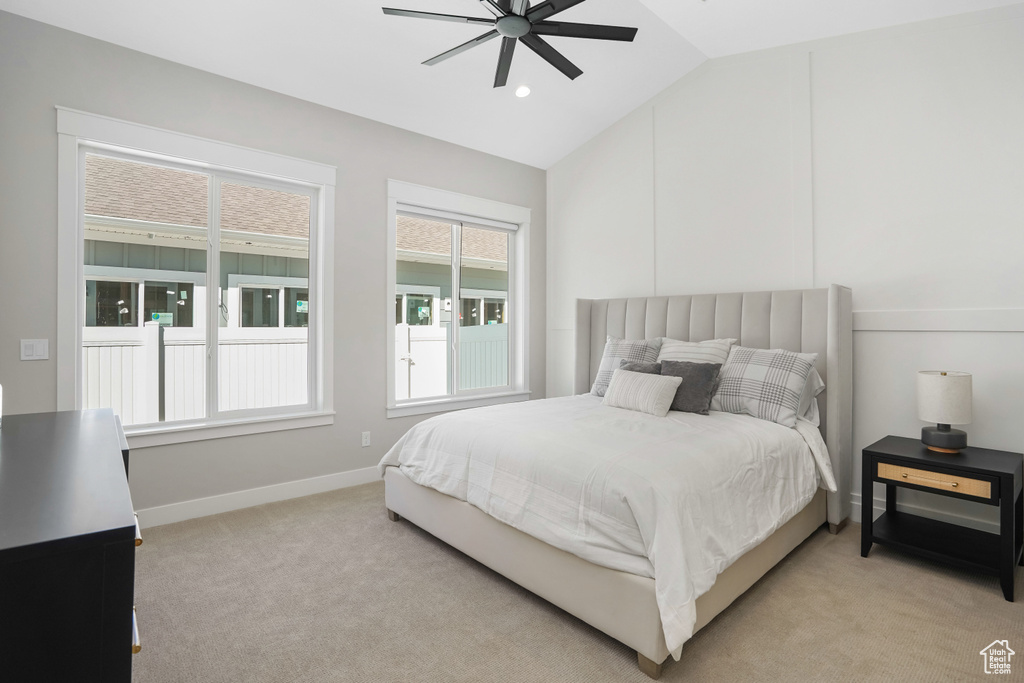 Carpeted bedroom featuring lofted ceiling and ceiling fan