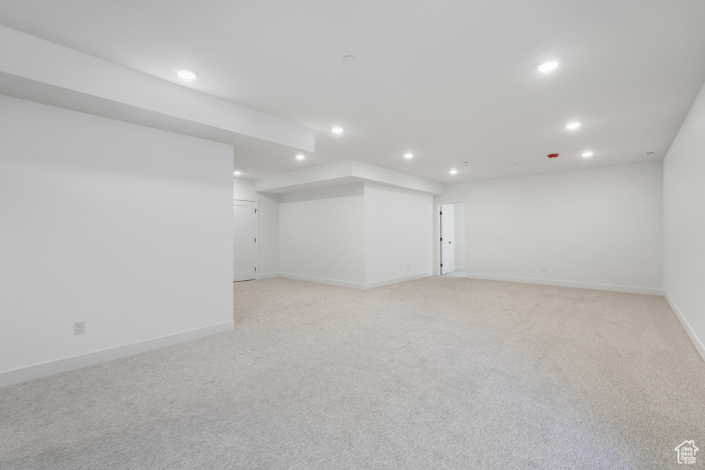 Basement featuring light carpet