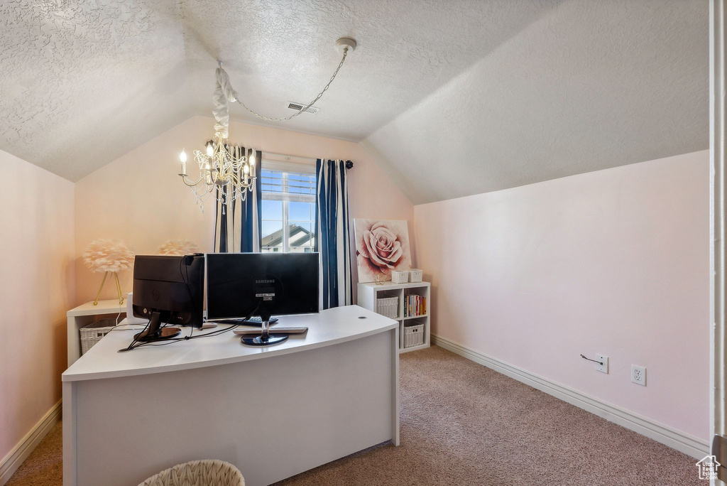 Office space featuring light carpet, vaulted ceiling, a textured ceiling, and a notable chandelier